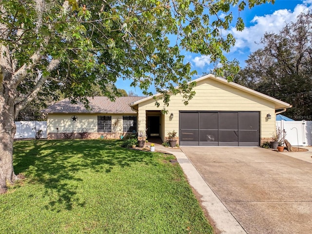 ranch-style home featuring concrete driveway, an attached garage, fence, and a front lawn