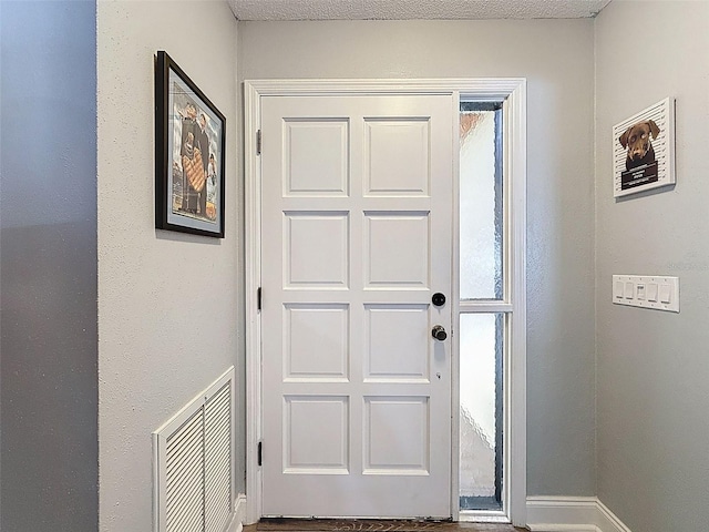 entryway featuring visible vents, baseboards, and a textured ceiling