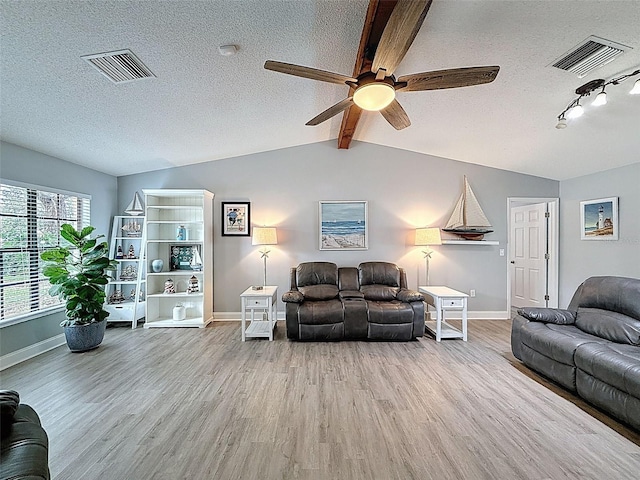 living room featuring visible vents, a textured ceiling, and wood finished floors