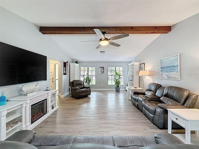 living room with lofted ceiling with beams, visible vents, baseboards, and a textured ceiling