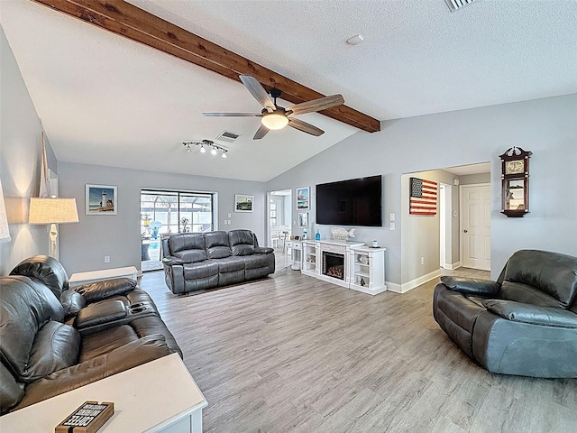 living area featuring vaulted ceiling with beams, a textured ceiling, baseboards, and wood finished floors