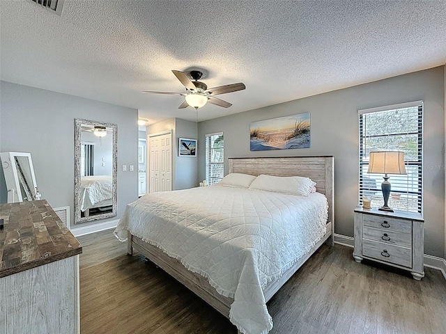 bedroom with visible vents, a closet, and dark wood-style floors