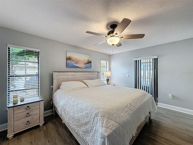 bedroom with a ceiling fan, baseboards, dark wood-style flooring, and a textured ceiling