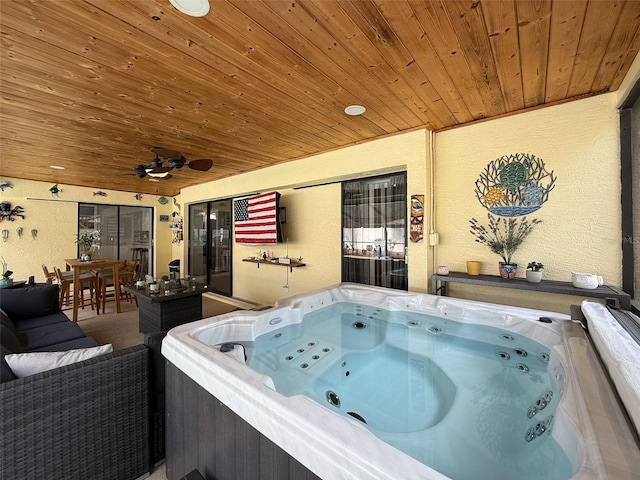 view of patio featuring outdoor dining area, a ceiling fan, and a hot tub