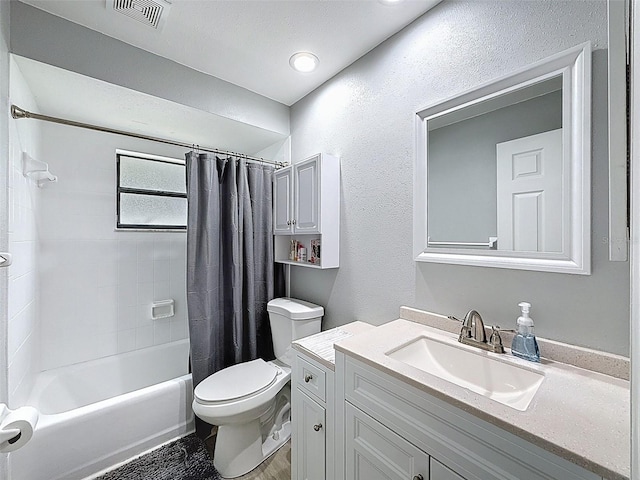 bathroom featuring visible vents, shower / bath combo with shower curtain, toilet, vanity, and a textured wall