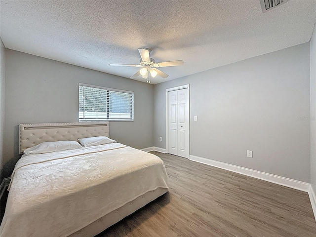 bedroom featuring visible vents, wood finished floors, baseboards, and ceiling fan