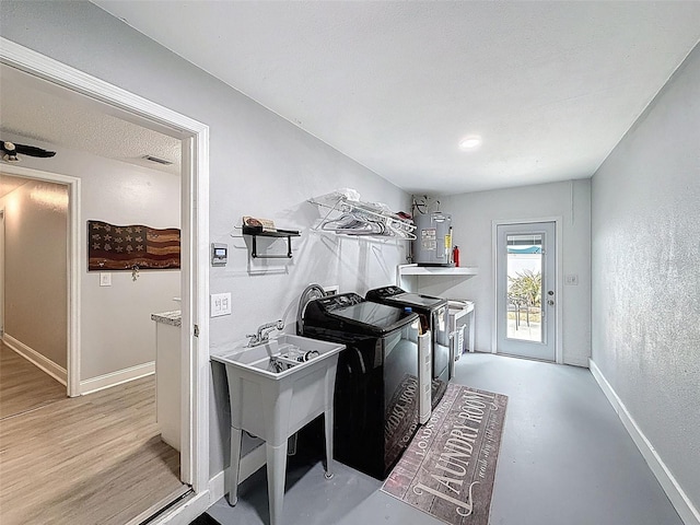 laundry room featuring baseboards, laundry area, a textured ceiling, a textured wall, and washer and clothes dryer