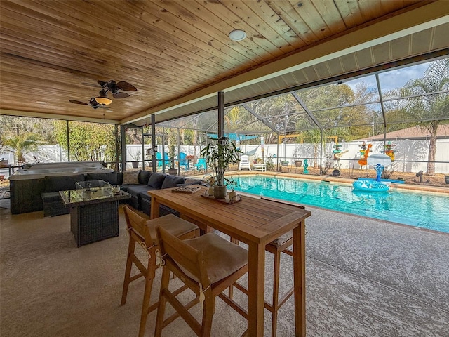 view of pool with glass enclosure, a fenced backyard, and a patio area