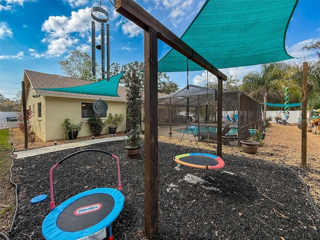 view of play area featuring glass enclosure and fence