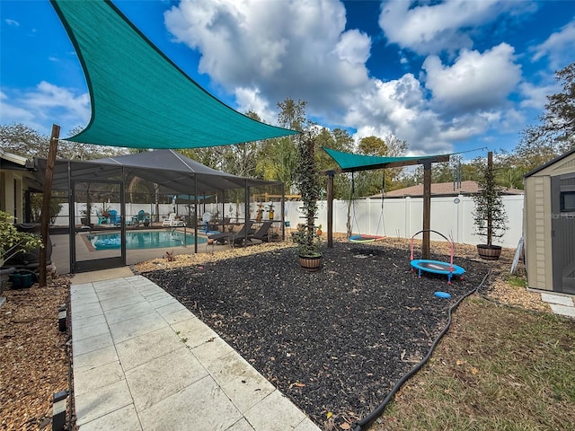 view of jungle gym with a fenced in pool, an outdoor structure, a fenced backyard, a patio area, and a storage unit