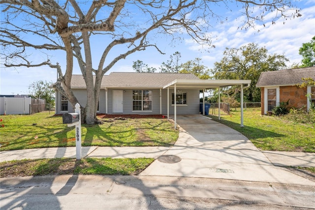 view of front of property featuring a front lawn, a carport, driveway, and fence