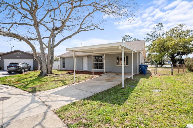 view of front of property with an outbuilding, a detached garage, a front yard, and fence