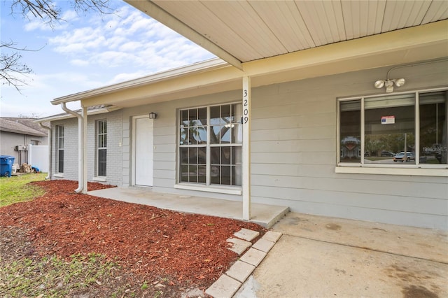 view of exterior entry with brick siding