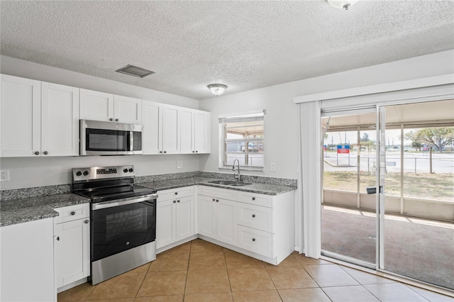 kitchen with a sink, visible vents, appliances with stainless steel finishes, and white cabinets