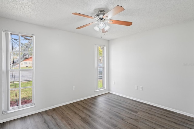 empty room featuring baseboards, a textured ceiling, dark wood-style floors, and a ceiling fan