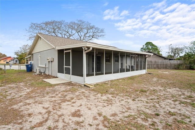 back of house with fence and a sunroom