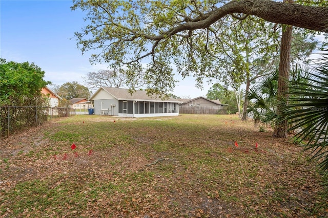 view of yard featuring a fenced backyard and a sunroom