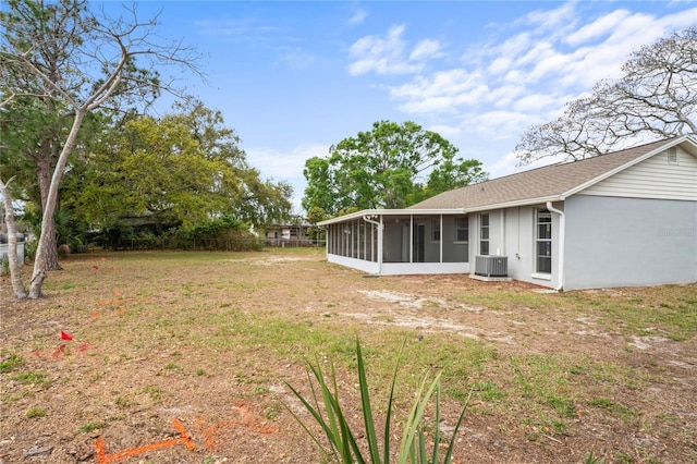 view of yard featuring central AC unit and a sunroom