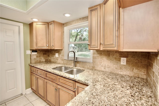 kitchen with light stone counters, light tile patterned floors, recessed lighting, a sink, and tasteful backsplash