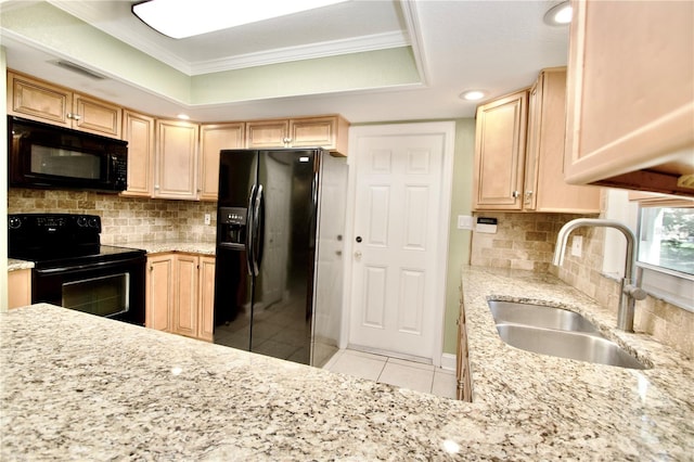 kitchen with black appliances, light brown cabinetry, a sink, light tile patterned floors, and a raised ceiling