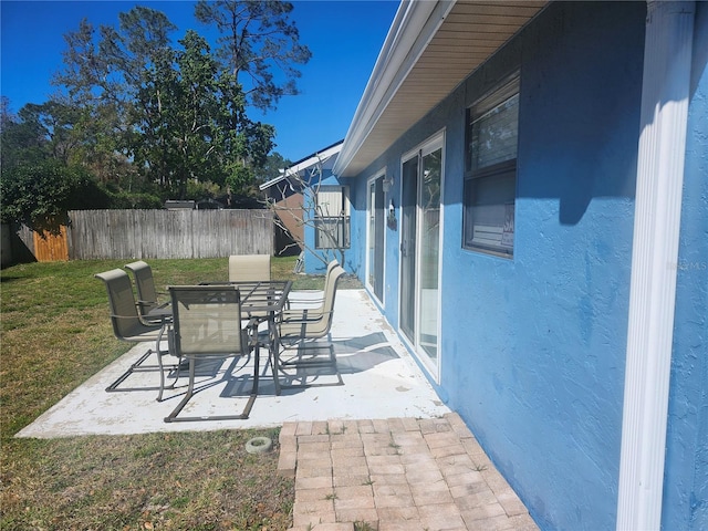 view of patio with outdoor dining space and fence