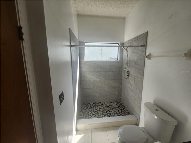 full bath with toilet, a shower stall, and a textured ceiling