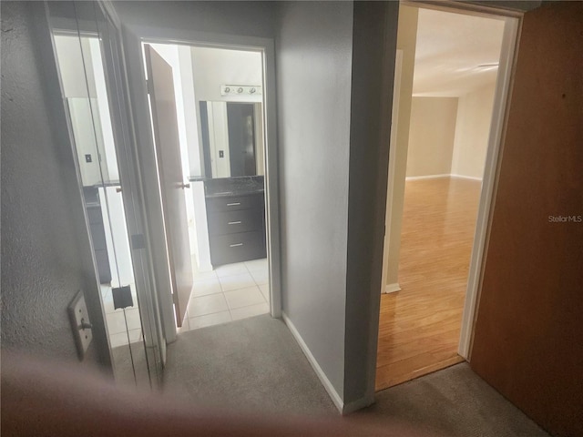 hall featuring baseboards and carpet