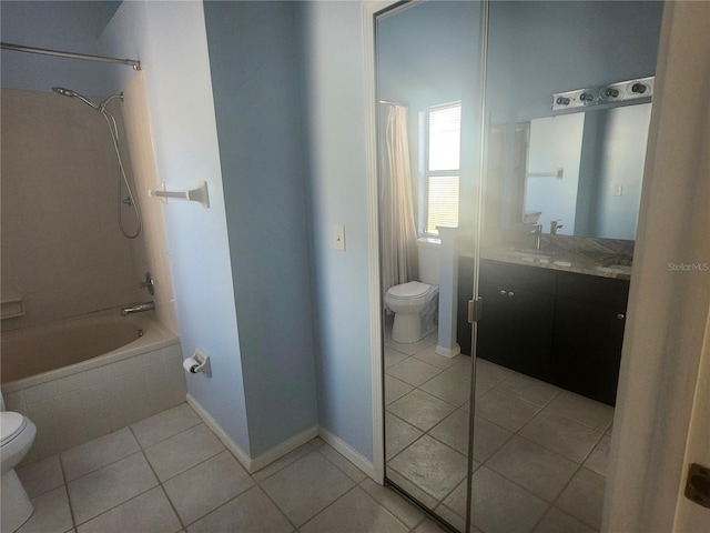 bathroom with tile patterned flooring, tiled shower / bath, toilet, and vanity
