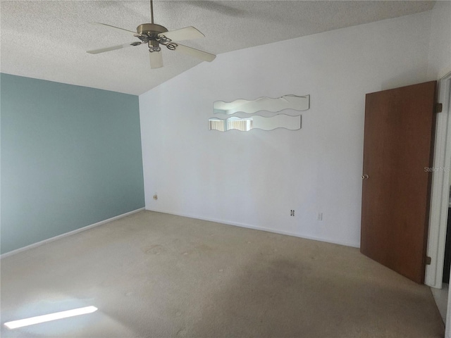 carpeted empty room featuring ceiling fan, lofted ceiling, baseboards, and a textured ceiling