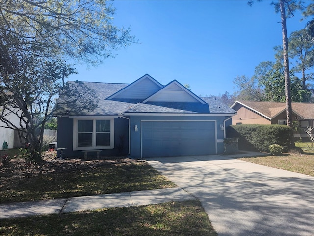 single story home with concrete driveway, a garage, and roof with shingles