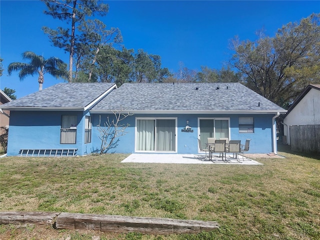 rear view of house featuring stucco siding, fence, a yard, a shingled roof, and a patio area