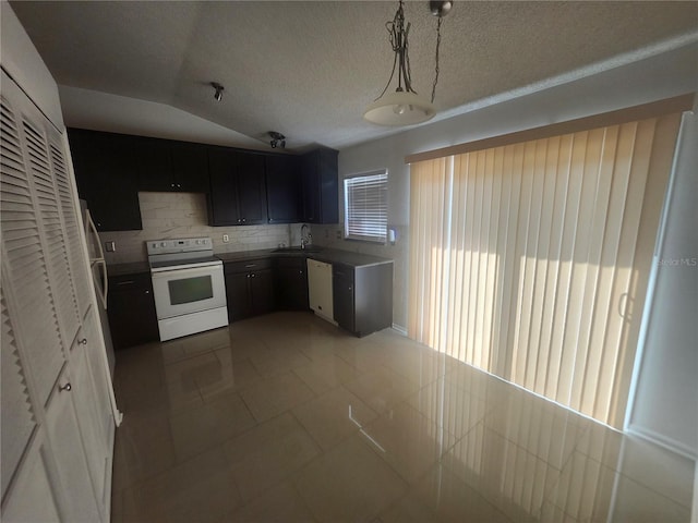 kitchen featuring a sink, a textured ceiling, tasteful backsplash, white appliances, and lofted ceiling