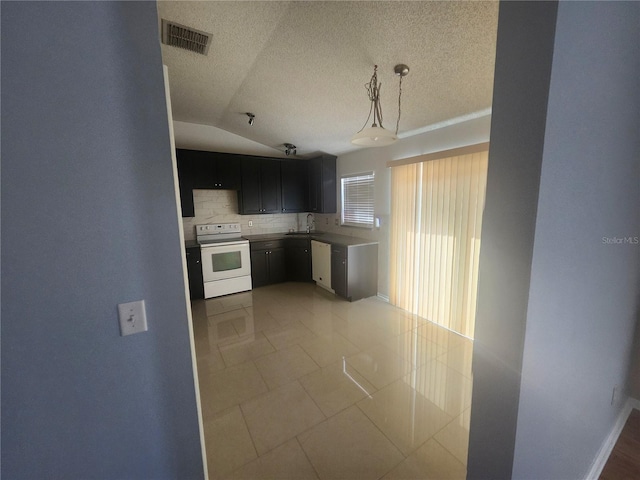 kitchen with visible vents, backsplash, lofted ceiling, light tile patterned flooring, and white appliances