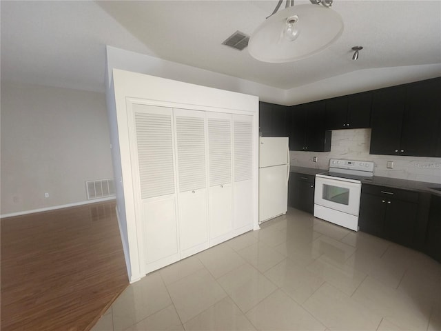 kitchen with visible vents, backsplash, white appliances, and dark cabinets
