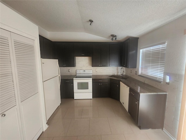 kitchen featuring white appliances, a textured ceiling, lofted ceiling, and a sink