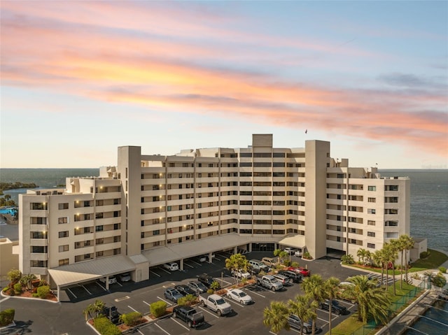 property at dusk featuring a water view and uncovered parking