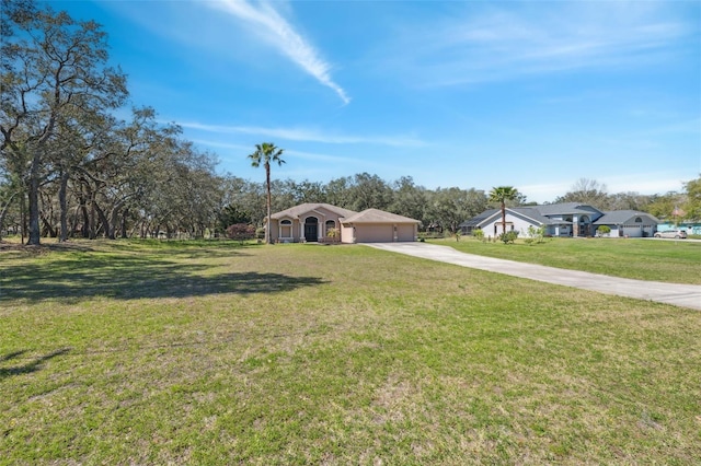 view of front of property with an attached garage, concrete driveway, and a front lawn