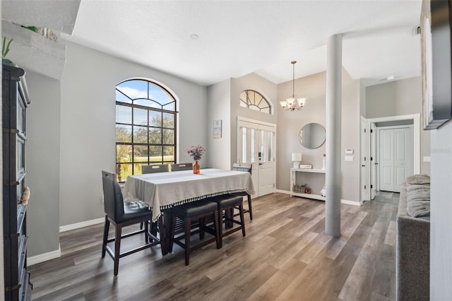 dining space with a chandelier, baseboards, and wood finished floors