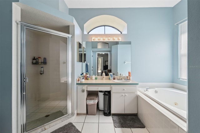 bathroom featuring tile patterned flooring, a tub with jets, a stall shower, and vanity