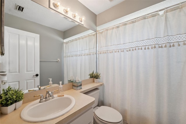 bathroom with visible vents, toilet, and vanity