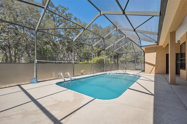 outdoor pool with glass enclosure and a patio