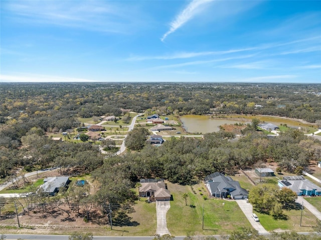 aerial view featuring a wooded view and a water view