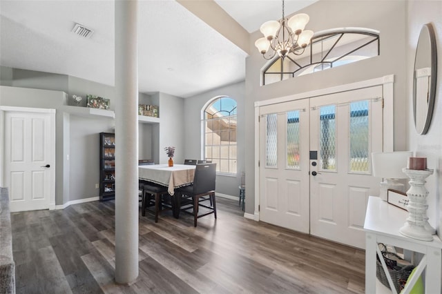 entrance foyer featuring visible vents, baseboards, dark wood-type flooring, and a chandelier