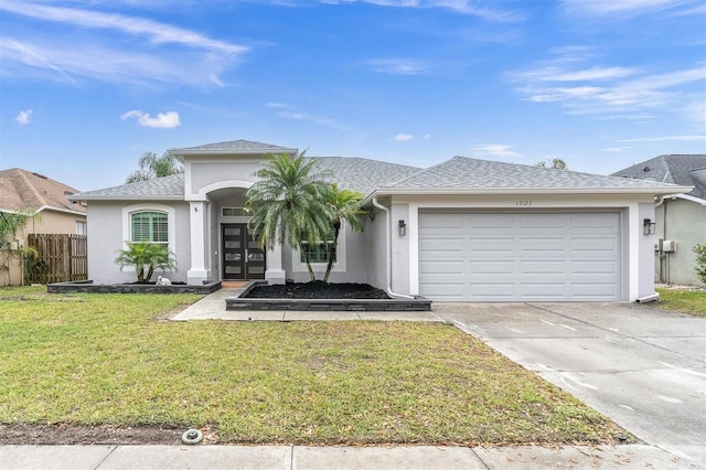 view of front facade featuring stucco siding, a front lawn, concrete driveway, and an attached garage