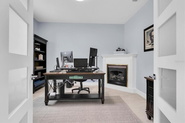 office featuring wood finished floors and a glass covered fireplace