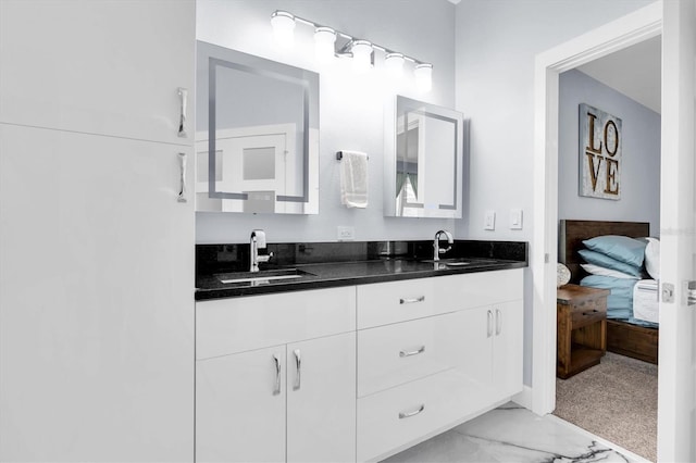 ensuite bathroom featuring ensuite bath, double vanity, marble finish floor, and a sink