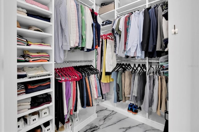 walk in closet featuring marble finish floor