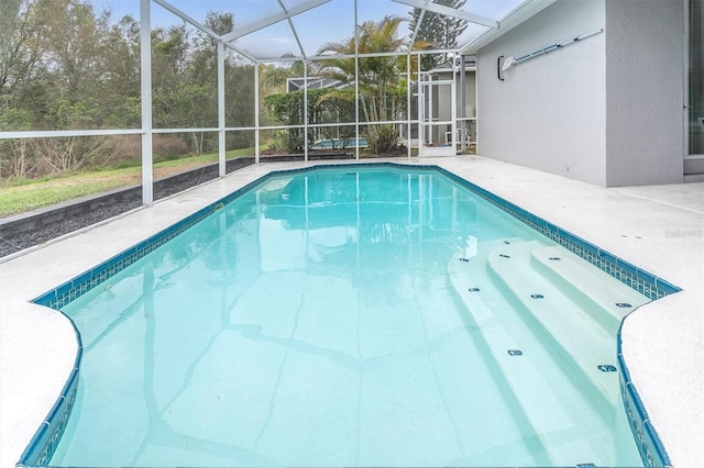 outdoor pool with glass enclosure and a patio