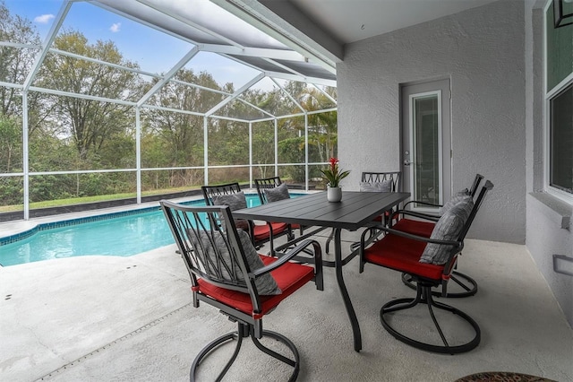 outdoor pool with outdoor dining space, glass enclosure, and a patio