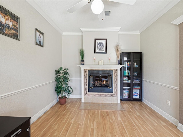 unfurnished living room with visible vents, wood finished floors, a fireplace, and crown molding